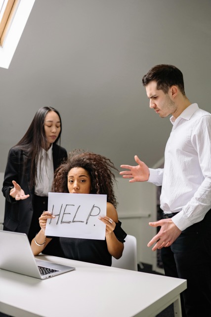 Personnes avec des relations interpersonnelles difficiles et une personne au milieu qui présente un panneau où il est écrit Help pour demander de l'aide